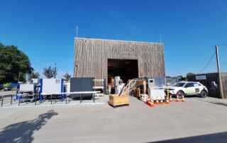 Bild der Forschungshalle, wie sämtlichen Laborgeräte vor der HAlle stehen und die Halle selbst leer ist.